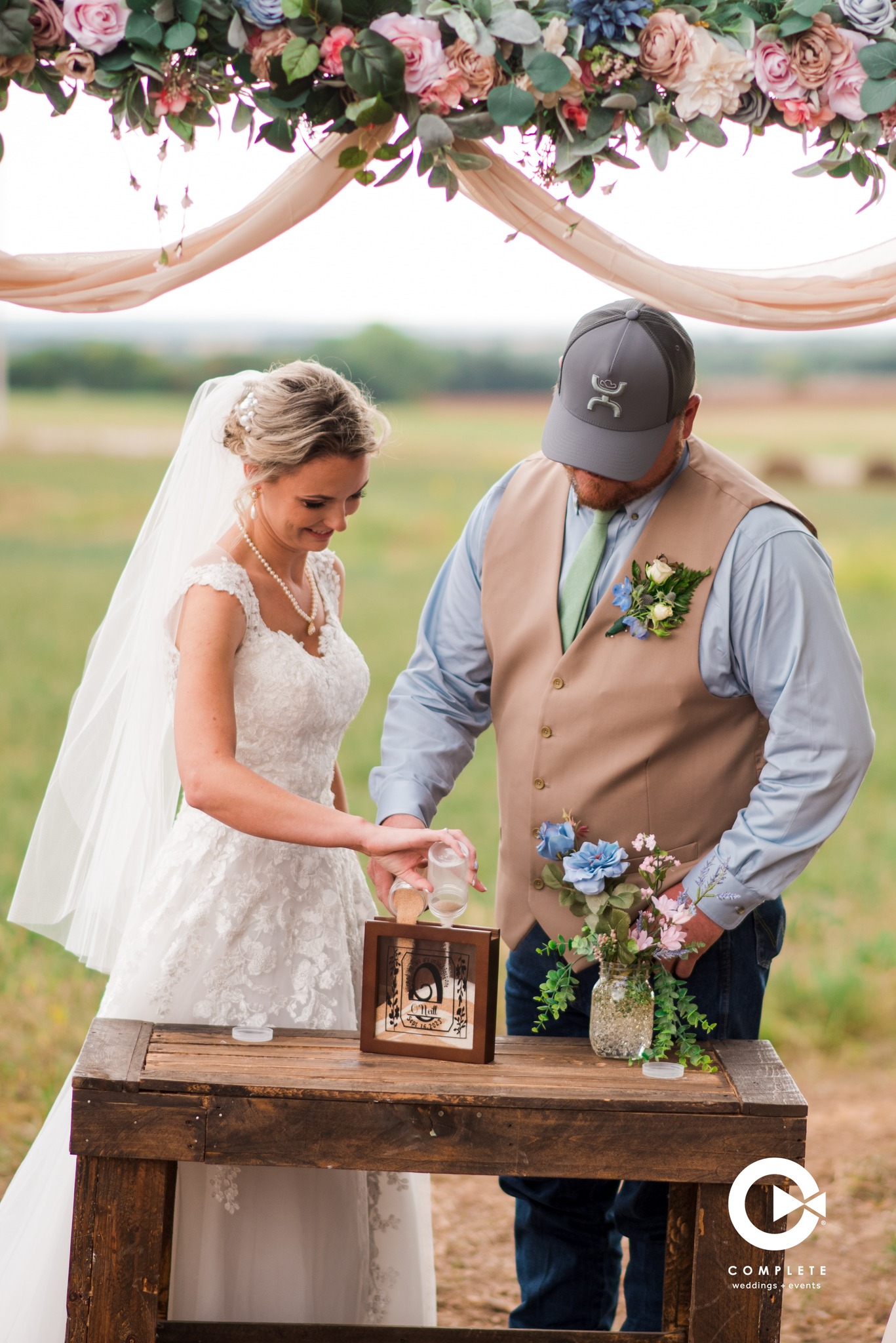 Bride and groom pouring sand into box